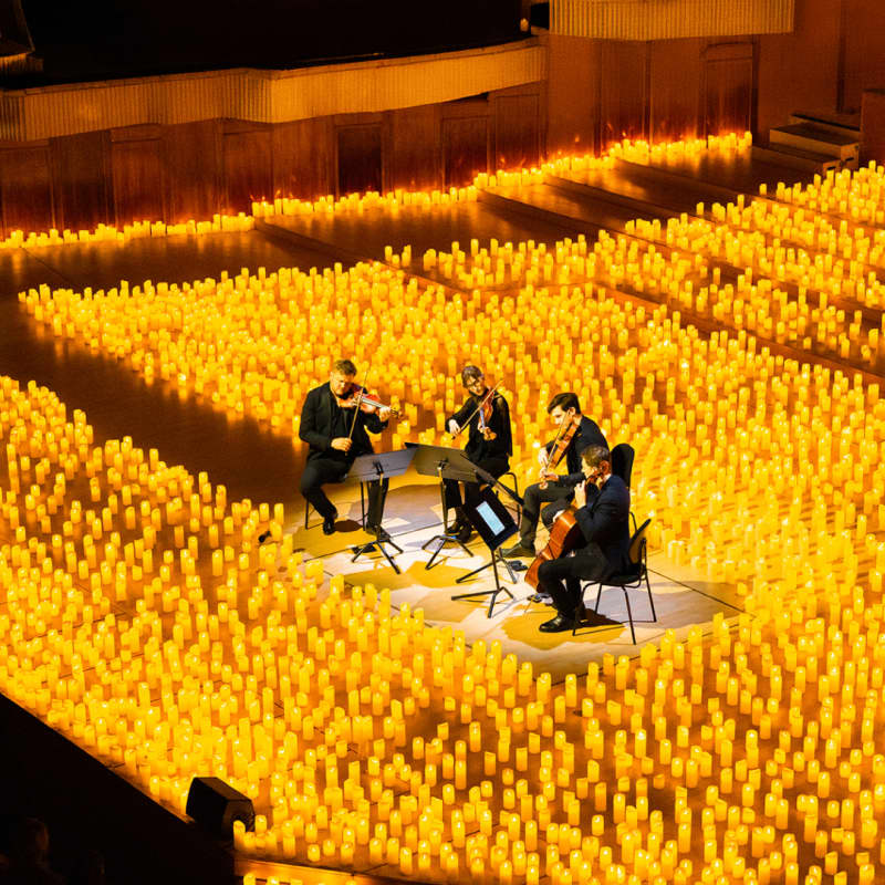 Ein Streichquartett spielt umgeben von Hunderten Kerzen